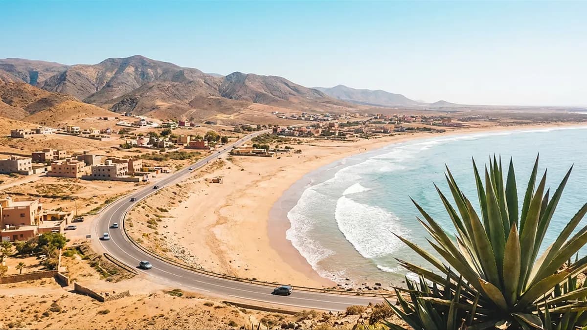 Panorama côtier d’Imi Ouaddar avec dunes dorées, falaises escarpées et océan Atlantique à perte de vue