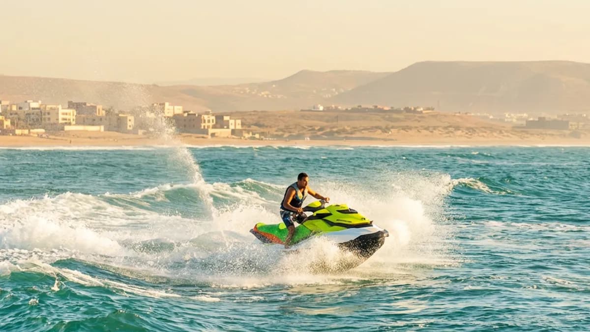 Un jet ski glissant sur une mer turquoise sous un ciel clair, entrepreneant une vague légère au large d’Agadir, sans bateaux ni chiffres visibles, mettant en valeur un moment dynamique de jet ski