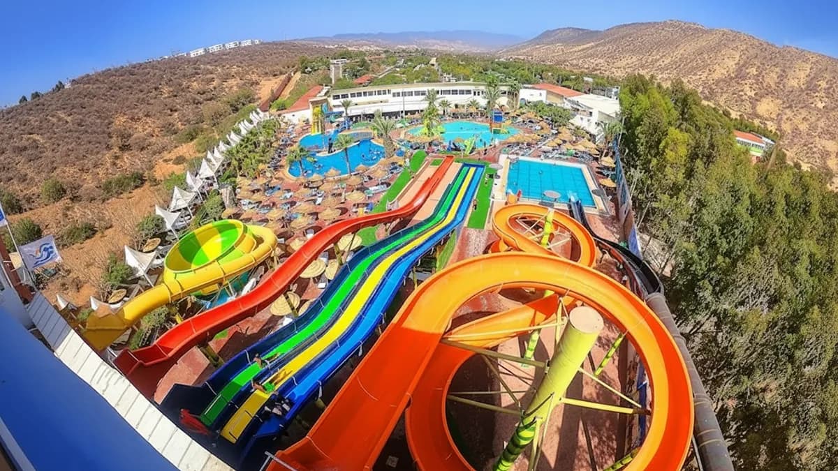 Vue aérienne d'Atlantica Park montrant des toboggans colorés, une piscine à vagues animée et des espaces de détente dans un cadre côtier – atlantica park