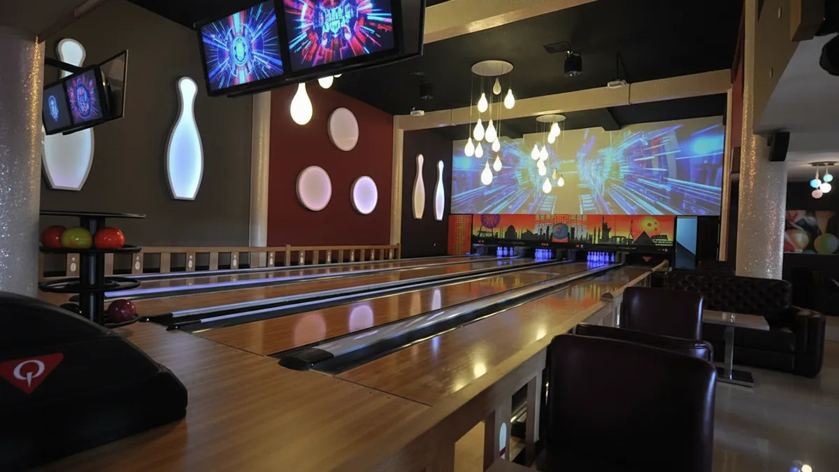 Intérieur moderne et convivial du centre agadir bowling à la Marina d'Agadir avec vue sur la plage, les yachts, tables lounge et bar design