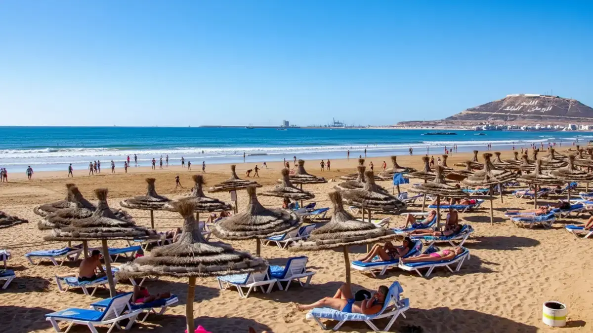 Panorama aérien d’Agadir au Maroc avec plage en arc, promenade bordée de palmiers et Atlantique d’un bleu profond